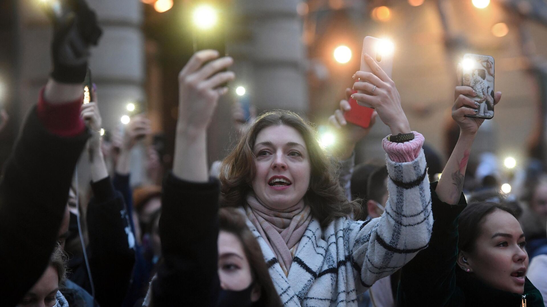 Участники несанкционированной акции в поддержку Алексея Навального держат смартфоны с включенными фонариками в Москве - РИА Новости, 1920, 21.04.2021