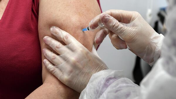 Женщина прививается от коронавирусной инфекции covid-19 в пункте вакцинации