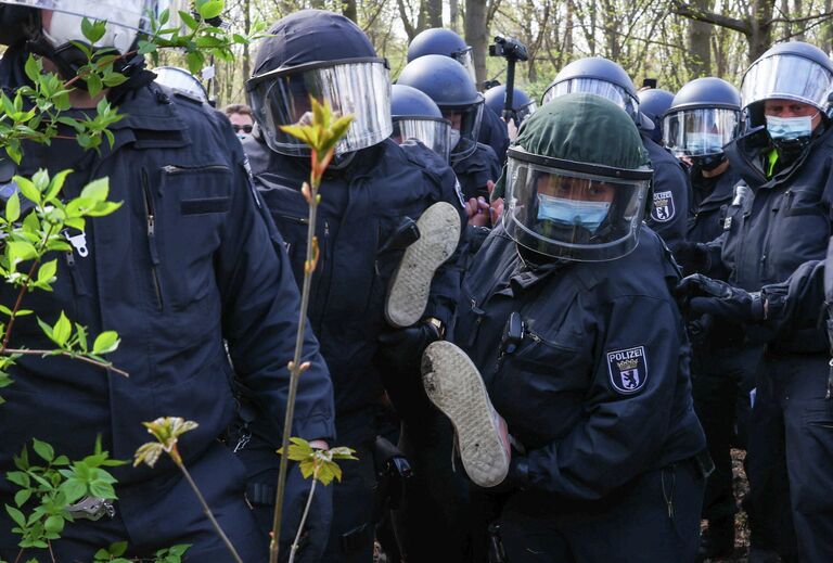 Полиция держит протестующего на акции протеста против коронавирусных ограничений в Берлине 