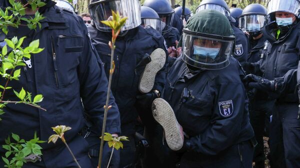 Полиция держит протестующего на акции протеста против коронавирусных ограничений в Берлине 