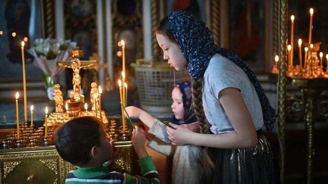 Прихожане во время службы в преддверии праздника Входа Господня в Иерусалим в храме в честь Воздвижения Честного и Животворящего Креста Господня в Омске