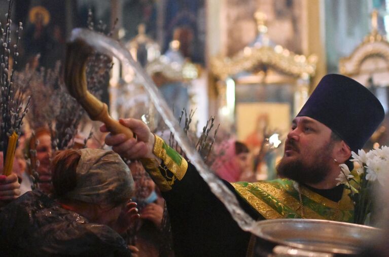 Священнослужитель во время службы в преддверии праздника Входа Господня в Иерусалим в храме в честь Воздвижения Честного и Животворящего Креста Господня в Омске