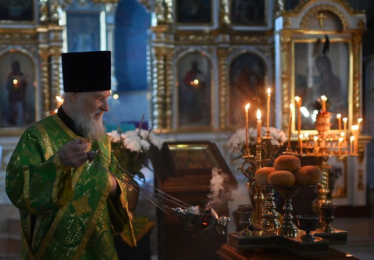 Священнослужитель во время службы в преддверии праздника Входа Господня в Иерусалим в храме в честь Воздвижения Честного и Животворящего Креста Господня в Омске