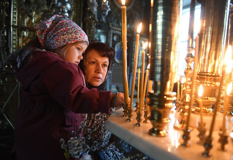 Прихожане во время божественной литургии, посвященной празднованию Входа Господня в Иерусалим, в храме Успения Пресвятой Богородицы в селе Стромынь в Московской области