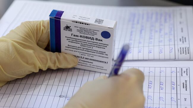 Медицинская сестра держит в руке упаковку с вакциной Гам-КОВИД-Вак (Спутник V) в пункте вакцинации от COVID-19