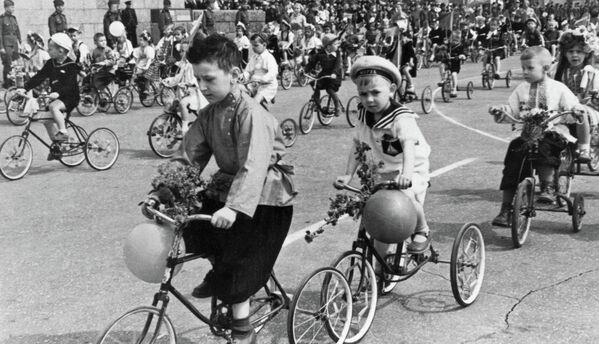Дети едут на велосипедах во время первомайской демонстрации в Сталинграде
