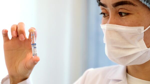 Медицинский работник держит в руках ампулу с российской вакциной от COVID-19 Спутник V в Центре семейной медицины №6 в Бишкеке