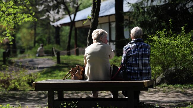 Женщины наблюдают за цветением сакуры в Главном ботаническом саду имени Н.В. Цицина Российской академии наук (РАН) в Москве