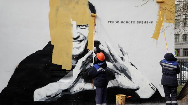 Коммунальные работники закрашивают граффити с изображением Алексея Навального в Санкт-Петербурге