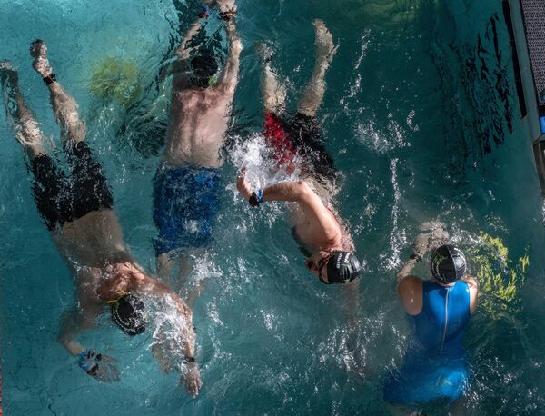 Участники ночного заплыва в бассейне под открытым небом Чайка в Москве