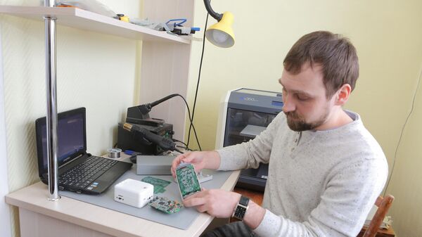 Степан Еньшин, инженер лаборатории Медицинская инженерия, в руках у него у него разработанный учеными аппаратно-программный комплекс для измерения микропотенциалов сердца (без сенсоров)