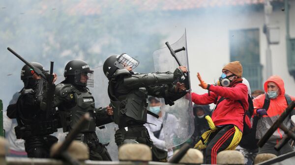 Столкновения демонстрантов с сотрудниками сил безопасности во время акции протеста против налоговой реформы правительства президента Ивана Дуке в Боготе, Колумбия. 28 апреля 2021 года