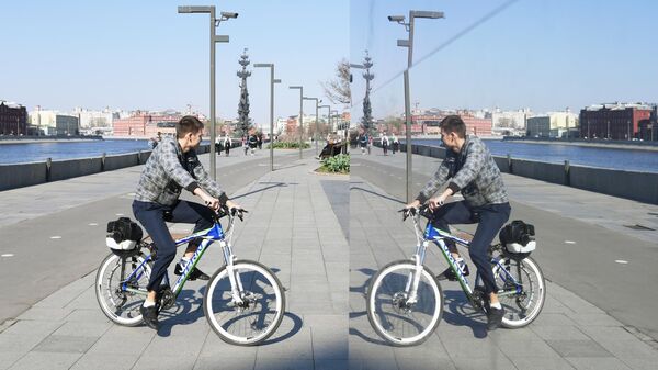 Молодой человек катается на велосипеде на Крымской набережной в парке искусств Музеон в Москве