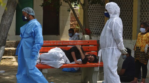Медицинские работники во время массовой кремации жертв пандемии в Дели