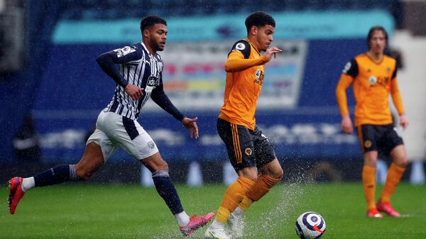 West Bromwich Albion's English defender Darnell Furlong (L) closes in on Wolverhampton Wanderers' English midfielder Morgan Gibbs-White during the English Premier League football match between West Bromwich Albion and Wolverhampton Wanderers at The Hawthorns in West Bromwich, central England on May 3, 2021. (Photo by Jason CAIRNDUFF / POOL / AFP) / RESTRICTED TO EDITORIAL USE. No use with unauthorized audio, video, data, fixture lists, club/league logos or 'live' services. Online in-match use limited to 120 images. An additional 40 images may be used in extra time. No video emulation. Social media in-match use limited to 120 images. An additional 40 images may be used in extra time. No use in betting publications, games or single club/league/player publications. / 