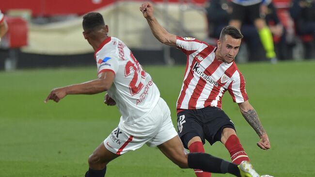 Athletic Bilbao's Spanish forward Alex Berenguer (R) fights for the ball with Sevilla's Brazilian midfielder Fernando during the Spanish League football match between Sevilla and Athletic Bilbao at the Ramon Sanchez Pizjuan stadium in Seville on May 3, 2021. (Photo by CRISTINA QUICLER / AFP)