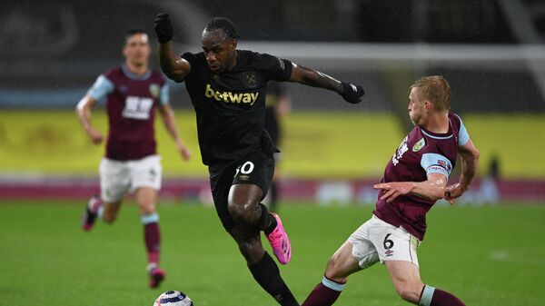 West Ham United's English midfielder Michail Antonio (C) avoids the tackle of Burnley's English defender Ben Mee during the English Premier League football match between Burnley and West Ham United at Turf Moor in Burnley, north west England, on May 3, 2021. (Photo by GARETH COPLEY / POOL / AFP) / RESTRICTED TO EDITORIAL USE. No use with unauthorized audio, video, data, fixture lists, club/league logos or 'live' services. Online in-match use limited to 120 images. An additional 40 images may be used in extra time. No video emulation. Social media in-match use limited to 120 images. An additional 40 images may be used in extra time. No use in betting publications, games or single club/league/player publications. / 