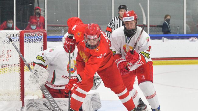 PLANO, TX USA - MAY 3: Russia's Dmitri Katelevski #12 controls the puck against Belarus's Maxim Sushinski #3 in quarterfinal round action at the 2021 IIHF Ice Hockey U18 World Championship at Children's Health StarCenter on May 3, 2021 in Plano, TX USA. (Photo by Ryan McCullough/HHOF-IIHF Images)