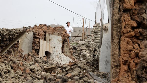 Девушка стоит у разрушенного строения в приграничном с Таджикистаном селе Кок-Таш
