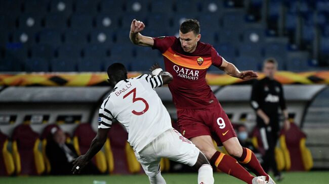 Roma's Bosnian forward Edin Dzeko (R) fights for the ball with Manchester United's Ivorian defender Eric Bailly during the UEFA Europa League semi-final second leg football match between AS Roma and Manchester United at the Olympic Stadium in Rome, on May 6, 2021. (Photo by Filippo MONTEFORTE / AFP)