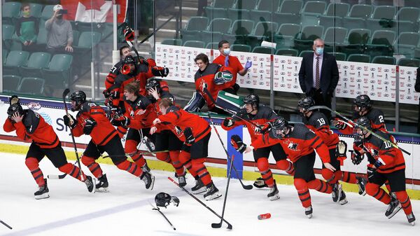 Хоккеисты юниорской сборной Канады празднуют победу на чемпионате мира