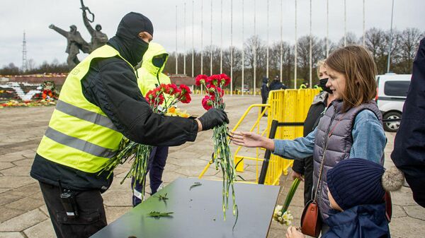 Рижане продолжают нести цветы к памятнику Освободителям Риги