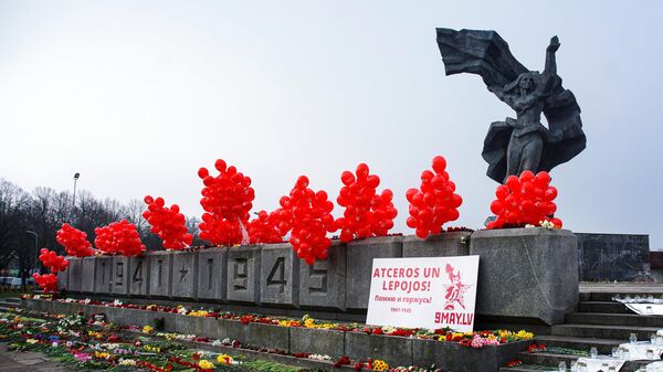 Воздушные шары и цветы у памятника Освободителям в Парке Победы в Риге в День Победы