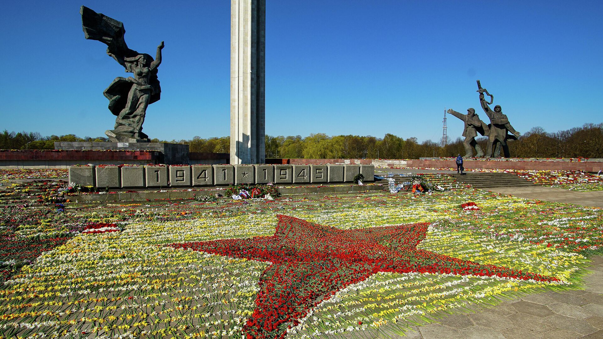 Красная звезда, выложенная волонтерами из цветов, возложенных к памятнику Освободителям в Парке Победы в Риге - РИА Новости, 1920, 10.05.2021