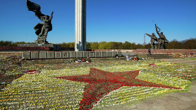 Красная звезда, выложенная волонтерами из цветов, возложенных к памятнику Освободителям в Парке Победы в Риге