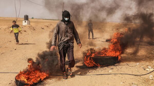 Палестинские протестующие жгут шины на территории сектора Газа у границы с государством Израиль