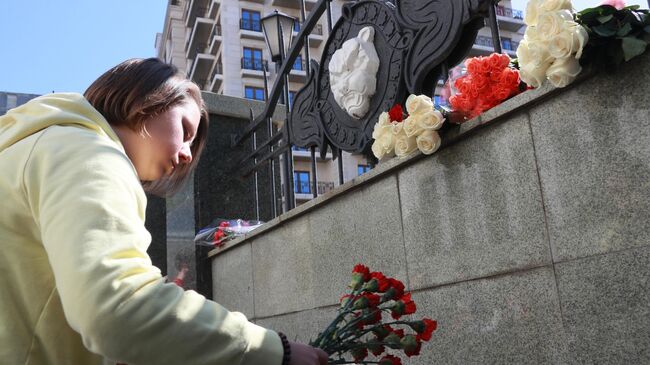 Девушка возлагает цветы в память о жертвах трагедии в казанской школе у здания Полномочного представительства Республики Татарстан в Российской Федерации в Москве