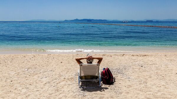 Отдыхающий на городском пляже Алимос в пригороде Афин