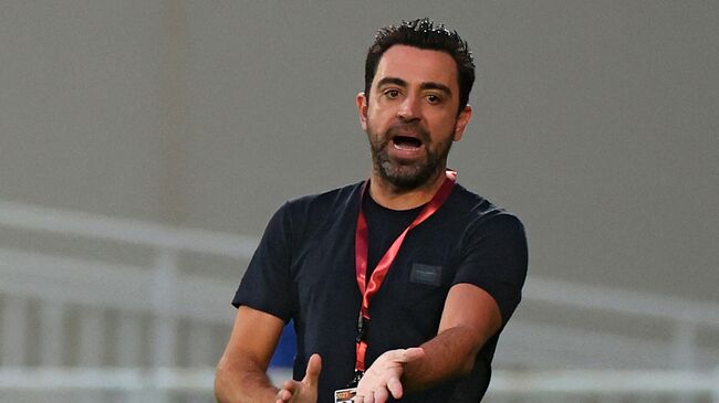 Sadd's coach Xavi Hernandez speaks to his player during the Qatar Cup semi-final football match between Al-Rayyan and Al-Sadd at the Abdullah bin Khalifa Stadium in the capital Doha on February 18, 2021. (Photo by KARIM JAAFAR / AFP)