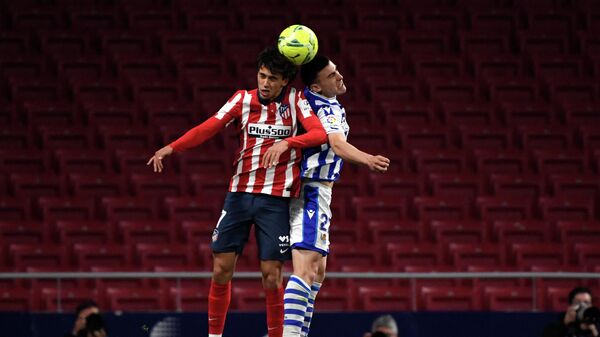 Atletico Madrid's Portuguese midfielder Joao Felix (L) jumps for the ball with Real Sociedad's Spanish forward Ander Barrenetxea during the Spanish league football match Club Atletico de Madrid against Real Sociedad at the Wanda Metropolitano stadium in Madrid on May 12, 2021. (Photo by PIERRE-PHILIPPE MARCOU / AFP)