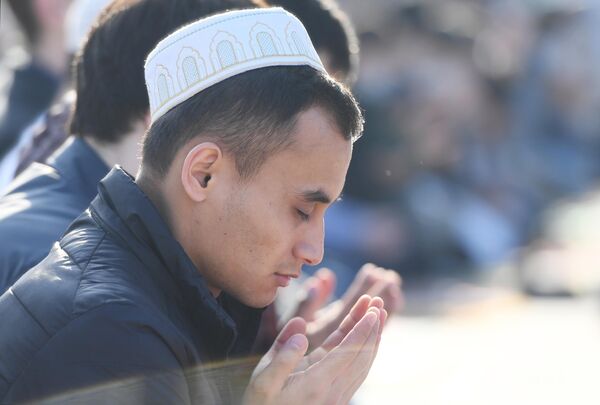Верующий во время праздничной молитвы в честь Ураза-байрама возле мечети Кул Шариф в Казани
