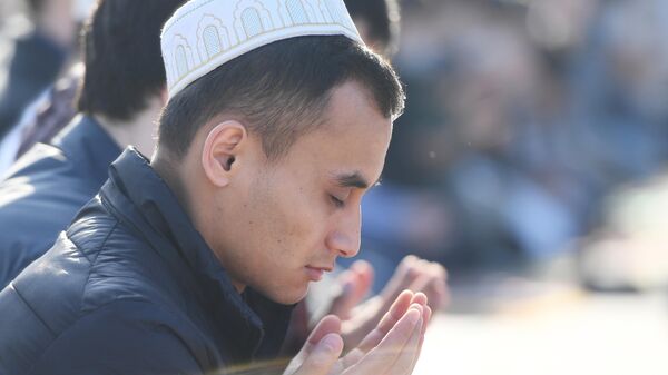 Верующий во время праздничной молитвы в честь Ураза-байрама возле мечети Кул Шариф в Казани