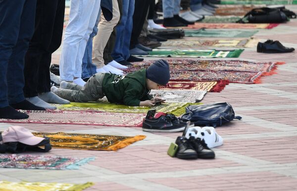Мальчик во время праздничной молитвы в честь Ураза-байрама возле мечети Кул Шариф в Казани