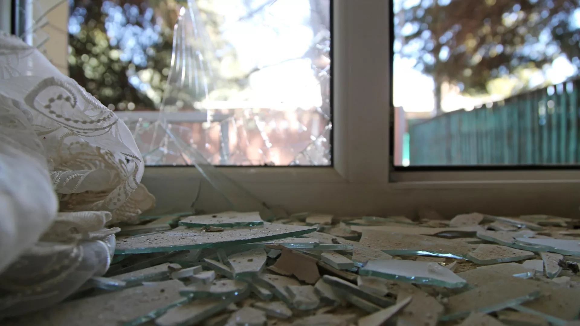 Разбитое окно дома, поврежденное разрывом снаряда в результате обстрела в Петровском районе Донецка - РИА Новости, 1920, 28.09.2021