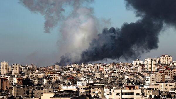 Дым поднимается на месте зданий, разрушенных израильским авиаударом в городе Газа
