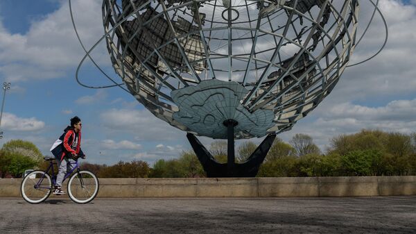 Мальчик проезжает на велосипеде мимо изображения Земли
