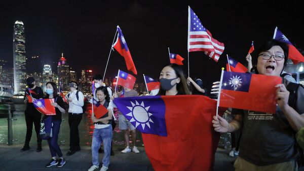 Люди c флагами Тайваня и США на митинге по случаю Национального дня Тайваня в Гонконге