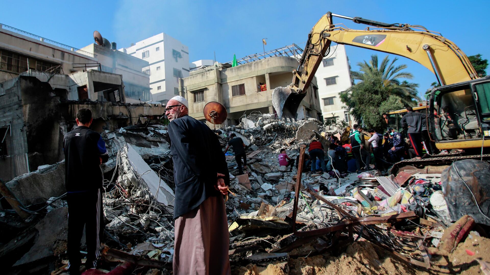 Спасатели разбирают обломки, разрушенного в результате бомбардировки здания, в секторе Газа - РИА Новости, 1920, 17.05.2021