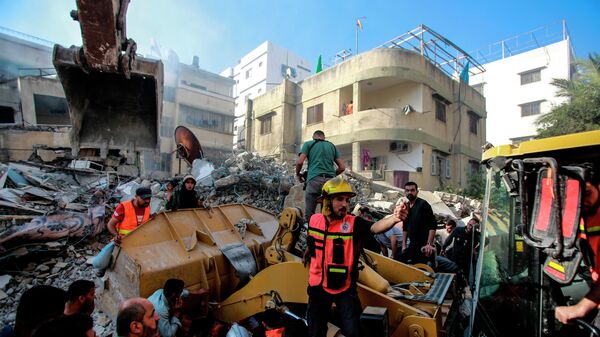 Спасатели разбирают завалы разрушенного в результате бомбардировки здания в секторе Газа