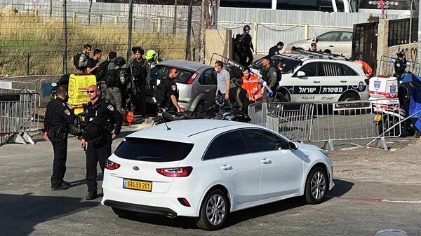 Израильские полицейские и медики работают на месте происшествия у въезда в район Шейх Джаррах в Восточном Иерусалиме