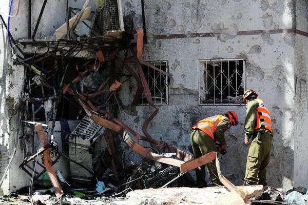 Последствия попадания ракеты, выпущенной из сектора Газа, в жилой дом в израильском Ашдоде