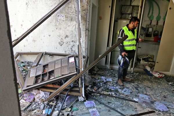 Последствия попадания ракеты, выпущенной из сектора Газа, в жилой дом в израильском Ашдоде