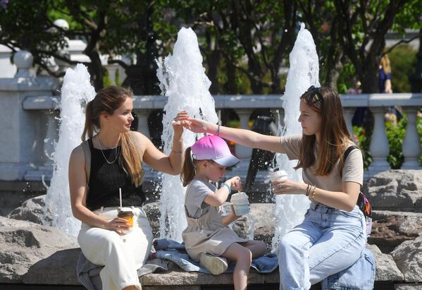 Женщина с детьми у фонтана на Манежной площади в Москве
