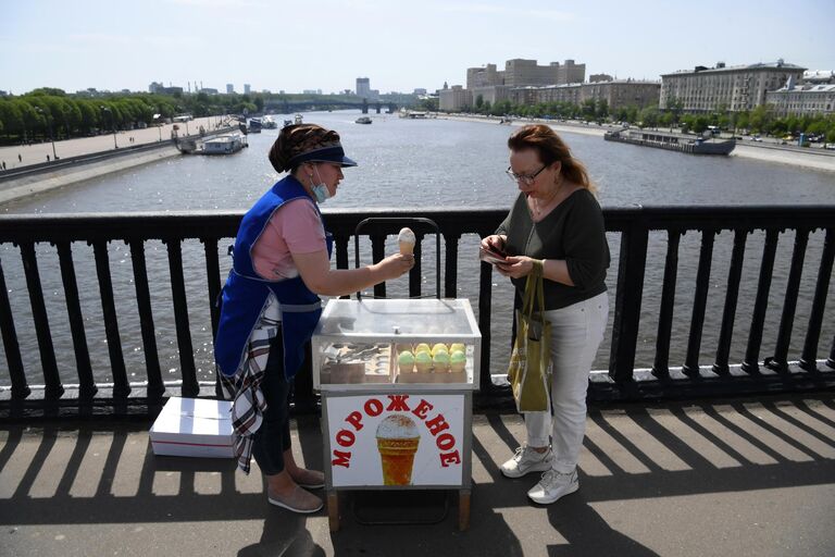 Женщина покупает мороженое на Крымском мосту в Москве