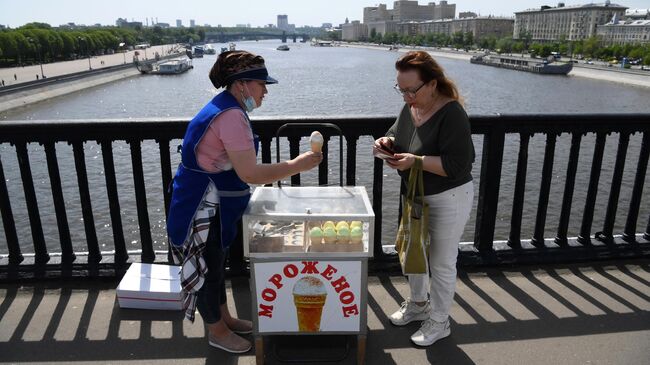 Женщина покупает мороженое на Крымском мосту в Москве