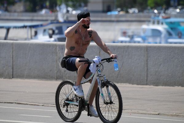 Молодой человек катается на велосипеде в Москве